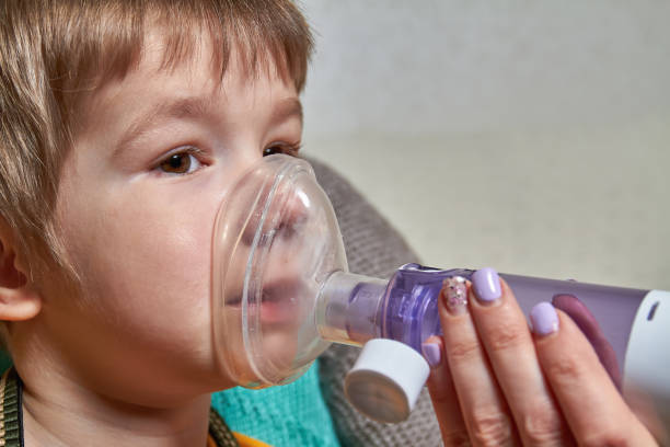 istock A small boy who suffering from illness bronchial asthma getting breathing treatment from mother with aerosol inhaler. Treatment of complications of viral diseases 1256487314