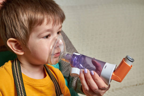 istock A small boy who suffering from illness bronchial asthma getting breathing treatment from mother with aerosol inhaler. Treatment of complications of viral diseases 1256487316