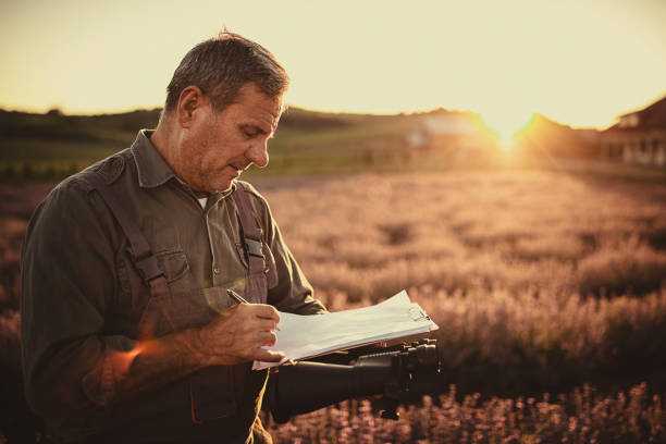 istock Mature male farmer with note pad in lavender field 1256491022