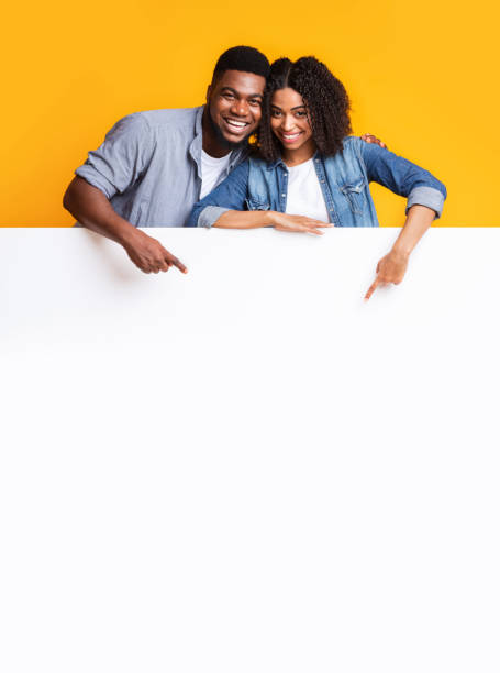 istock Blank Smiling Couple Pointing At Blank Advertisement Board, Recommending Something 1256492277
