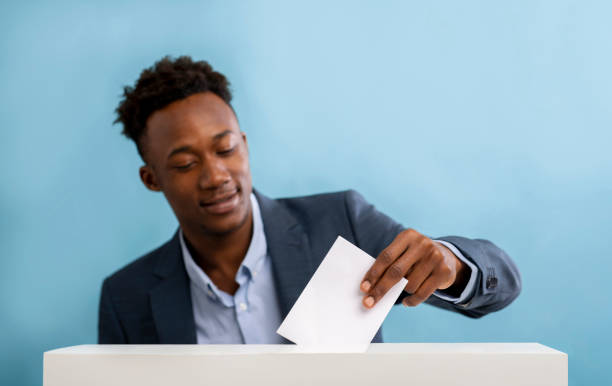 istock African american man pulls envelope into vote ballot 1256492284