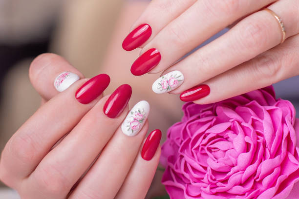 istock Beautiful female hands with pink manicure, peonies design 1256493290