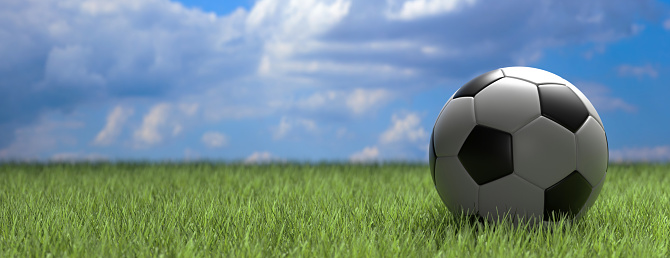 Soccer ball, football. White and black ball close up view, on green grass field, blue sky background, banner, copy space. 3d illustration