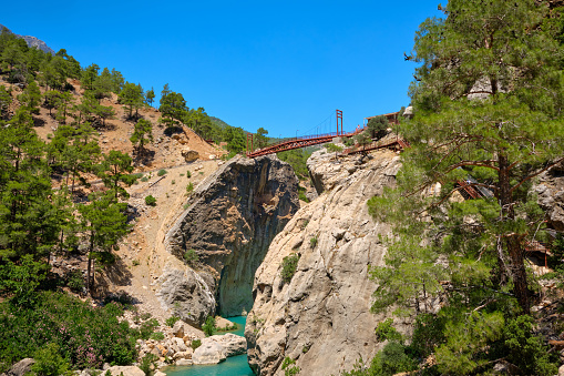 Metal pedestrian bridge over the gorge and mountain river. Yerkopru waterfall, Ermenek river, Mersin province,Turkey.