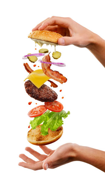 クックはハンバーガーを作っています。白の上の飛ぶ層 - symmetry burger hamburger cheese ストックフォトと画像