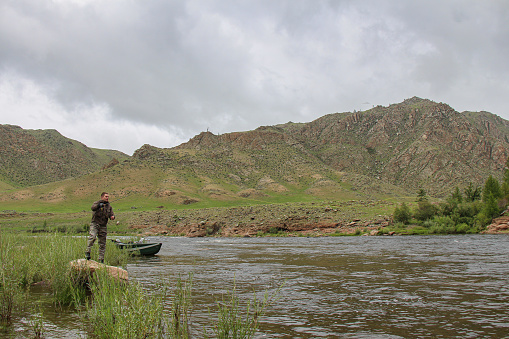 Fly fisherman casting a fly on the Delger Moron river in Mongolia during the summer - Moron, Mongolia - July 14th 2014