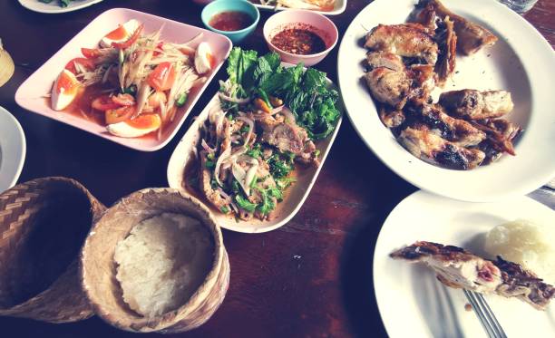 Som Tum (Thai Papaya Salas) and thai food on table.