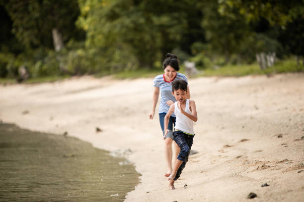 istock mother chasing little boy on the beach 1256496653