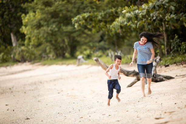 istock mother chasing little boy on the beach 1256496654