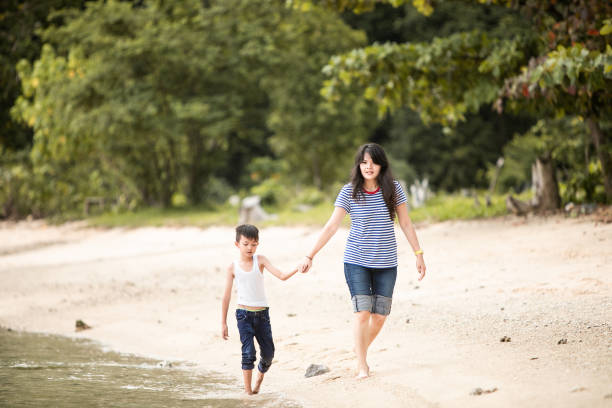 istock mother chasing little boy on the beach 1256497029