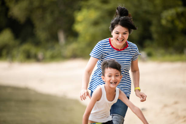 istock mother chasing little boy on the beach 1256497082