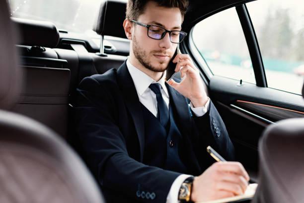 istock Businessman writing in notebook sitting in his car 1256497227