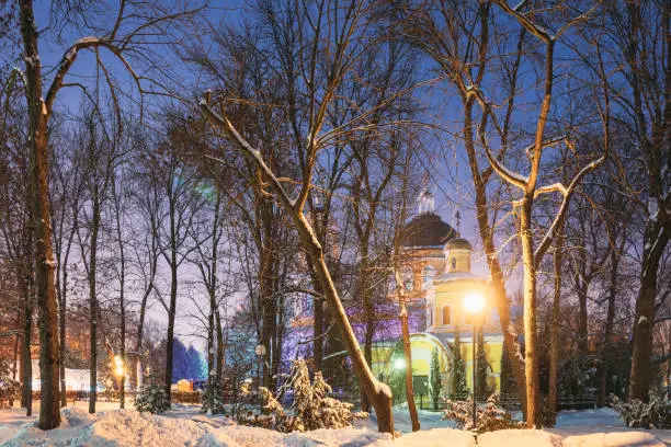 Photo of Gomel, Belarus. City Park In Winter Night. Peter And Paul Cathedral In Homiel Rumyantsevs And Paskeviches Park. Famous Local Landmark In Snow