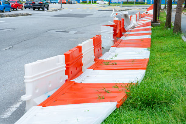 plastic blocks restricting the passage of cars during repair work. safe plastic road fences - cyclone fence imagens e fotografias de stock