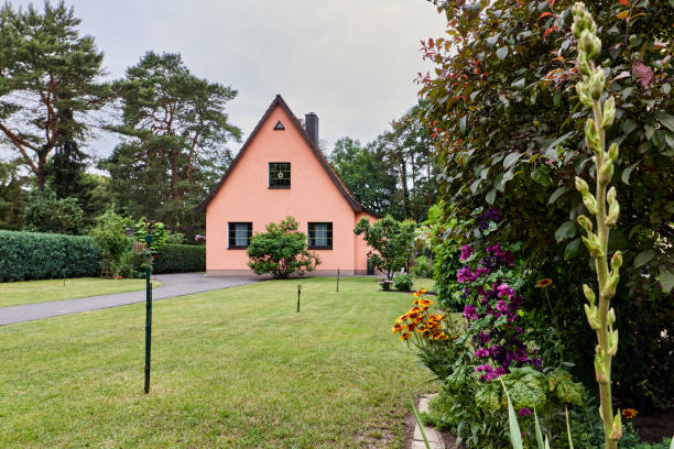 DSLR full frame wide angle view image of a small private house at an overcast morning in Germany with a frontyard and a large meadow