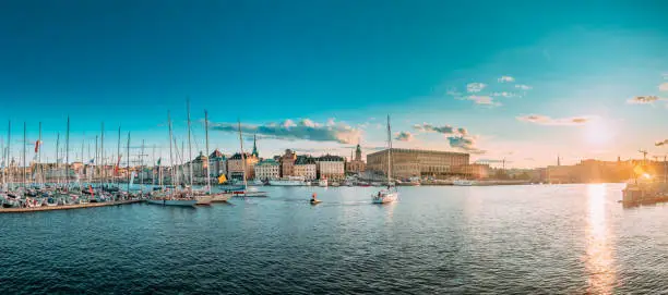 Photo of Stockholm, Sweden. Scenic Famous Panoramic View Skyline Of Old Town. Stockholm Cityscape In Sunset Lights. Jetty With Many Moored Yachts During Sailing Regatta. Popular Destination Place