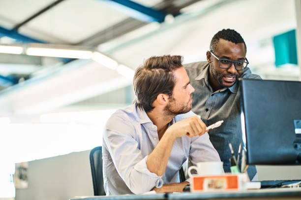 istock Diverse designers working together at a desk in a modern office 1256508275