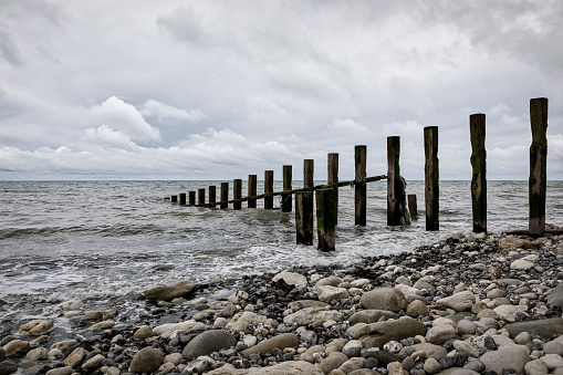 Wooden groyns in pebbly beach on the coast of Eastbourne,East Sussex,United Kingdom