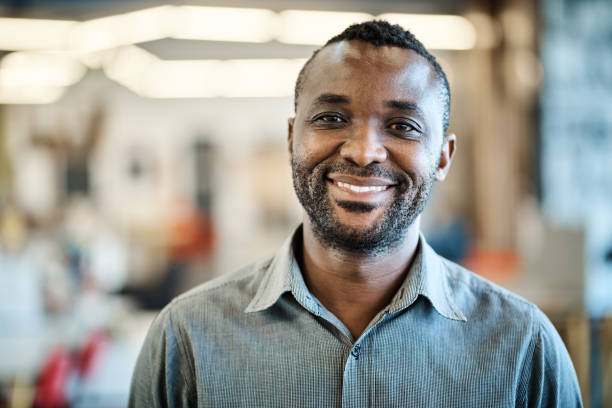 istock Smiling African American designer standing in an open plan office 1256511328