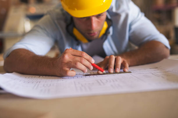 istock Carpenter underlining part of blueprint 1256511597
