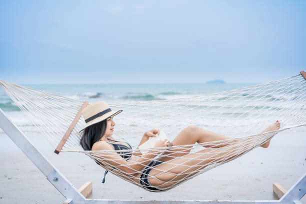 istock A woman reading a book on the beach. 1256513070