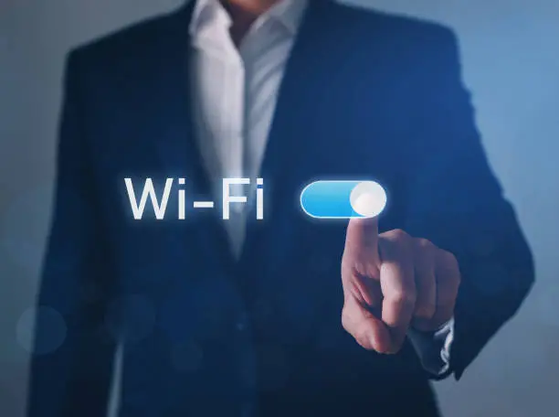 Photo of Businessman hand switch on Wi-Fi button. Wi-Fi wireless concept. Free WiFi network signal technology internet concept.