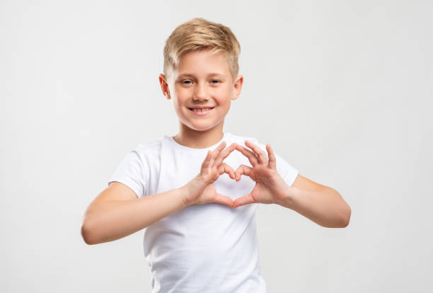 love sign friendly blond boy showing heart gesture Love sign. Affection compassion. Friendly blond boy showing heart gesture isolated on neutral background. cute boy show love symbol hand stock pictures, royalty-free photos & images