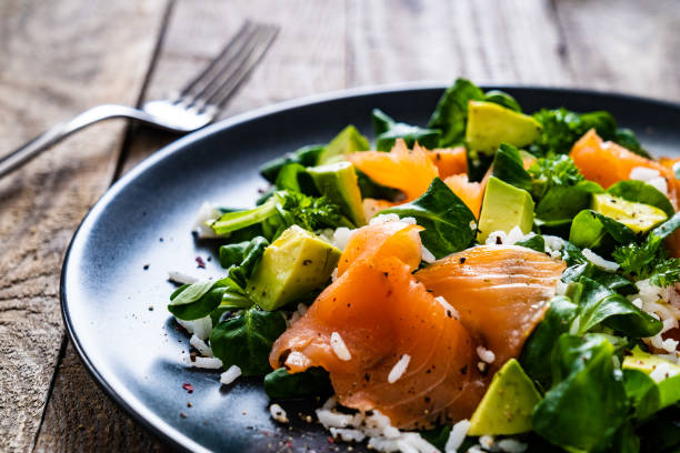 istock Vegetable salad with smoked salmon on wooden background 1256520685