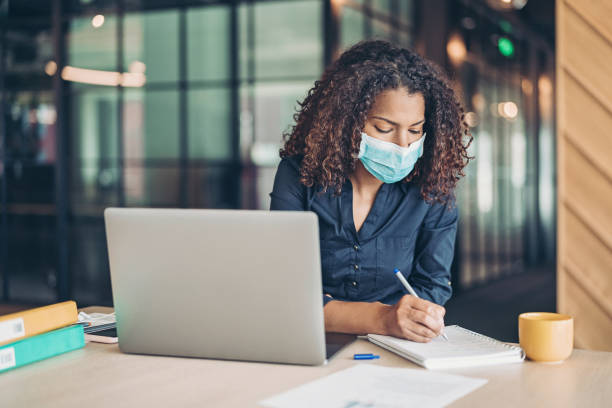 COVID-19 spread prevention Businesswoman working wearing a protective mask state of emergency stock pictures, royalty-free photos & images