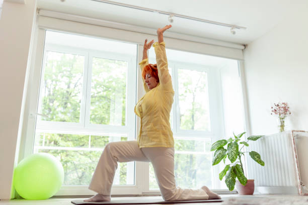 istock Senior woman doing yoga exercises 1256522878