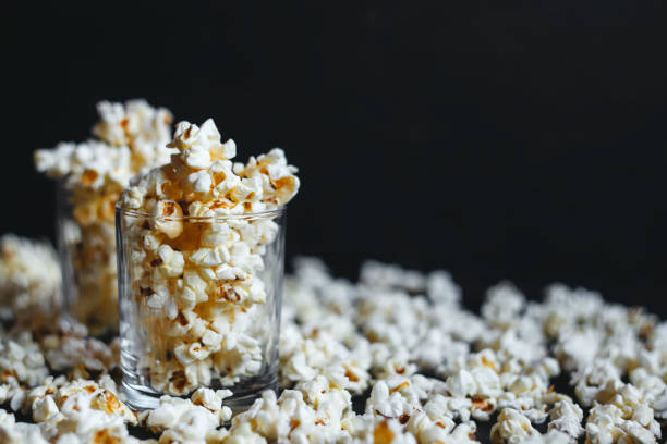 istock Salted popcorn in a glass on a black background. 1256525689