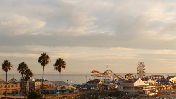 ruota panoramica classica, parco divertimenti sul molo nel resort sulla spiaggia dell'oceano pacifico di santa monica. estetica estiva californiana, vista iconica, simbolo di los angeles, ca usa. cielo dorato al tramonto e attrazioni - santa monica retro revival ferris wheel carnival foto e immagini stock