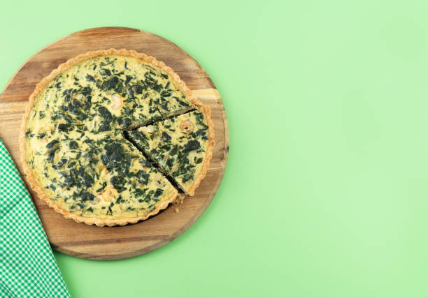 istock Vegetable quiche with portion cut on kitchen board and green background. Copy space. 1256530514