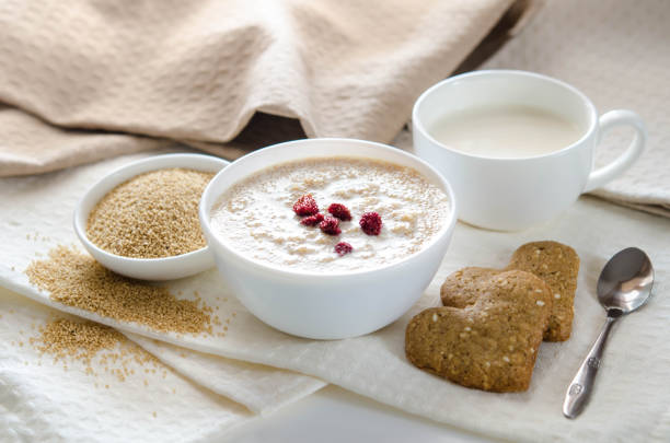 Sesame dry cookies in the form of heart, porridge of amaranth and yogurt, healthy breakfast stock photo