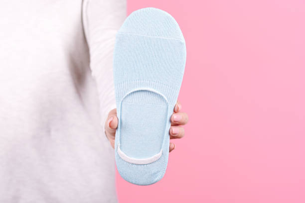 istock Hand with new cotton socks. Isolated on pink background. 1256531881