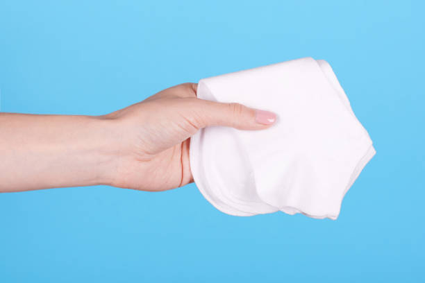 istock Hand with new white cotton socks. Isolated on blue background. 1256532010