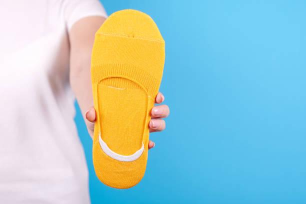 istock Hand with new cotton socks. Isolated on blue background. 1256532360