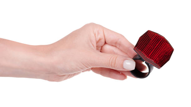 istock Hand with red bicycle reflector for safety. Isolated on white background. 1256534890