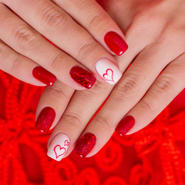istock Beautiful female hands with red manicure, hearts design 1256535994