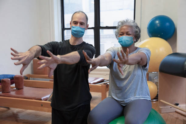 people doing exercise At rehab center wearing mask stock photo