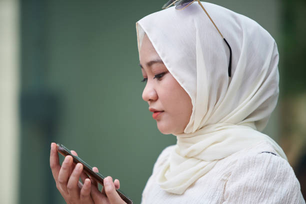 perfil ver mulher malaia usando hijab usando telefone - hijab profile teenager islam - fotografias e filmes do acervo