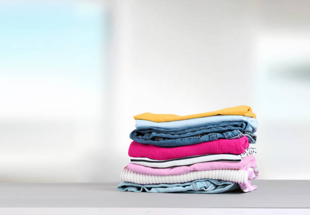 istock Stack of colorful clothing,cotton folded clothes stacked.Apparel on table empty copy space. 1256543314
