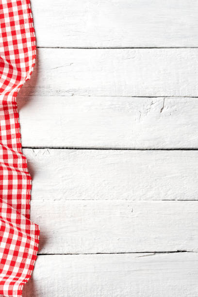 istock Red checkered tablecloth on white old wooden table with copyspace 1256547135