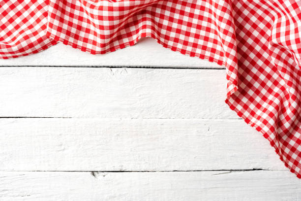 istock Red checkered tablecloth on white wooden table. Top view 1256547761