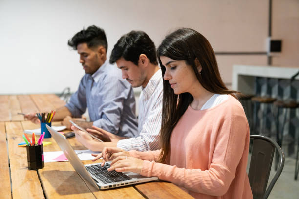 istock Portrait of three young adults working at night at co-working space 1256548131