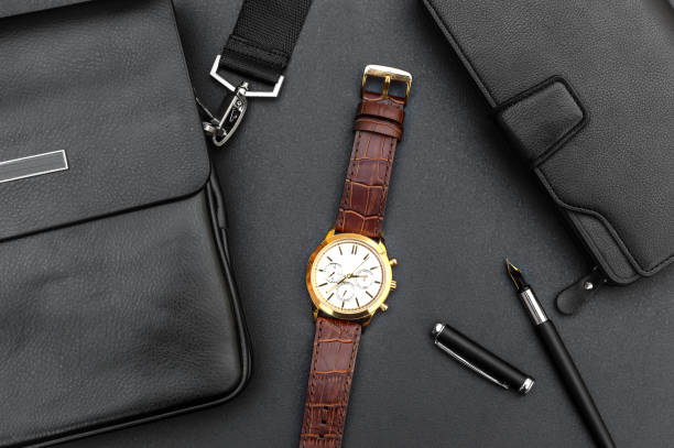 istock Man's wrist watch with handbag and purse on black. 1256548453