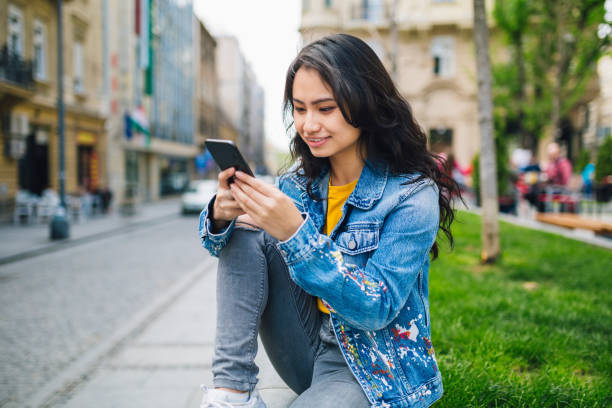 istock Cheerful young Asian woman using a smart phone 1256550918