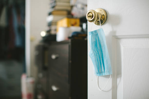 Protective face mask hanging on door knob