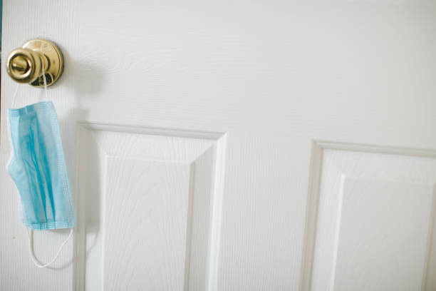 istock Protective face mask hanging on door knob 1256552779