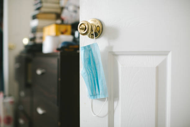 istock Protective face mask hanging on door knob 1256552845